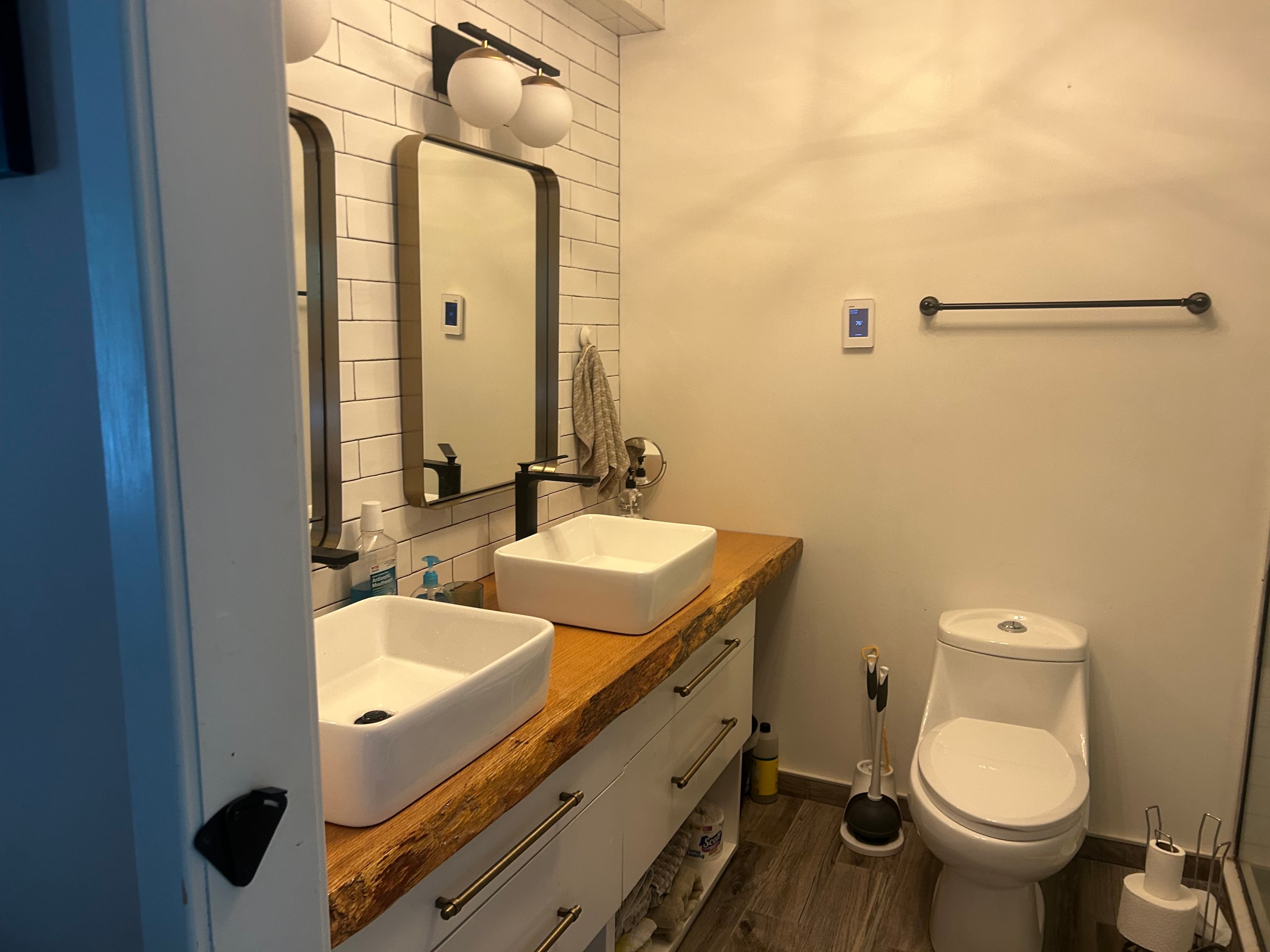 Primary bathroom — dual sinks, reclaimed-wood vanity, subway tile